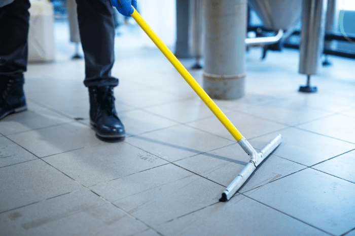 Persona realizando una limpieza post obra en profundidad del suelo.